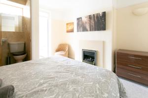 1 dormitorio con 1 cama y chimenea en Shrewsbury Cottage, en Shrewsbury