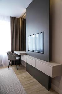 a hotel room with a television on a wall at ZEST Residence in Kragujevac