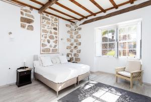 biała sypialnia z łóżkiem i krzesłem w obiekcie Detached Villa with Garden, Heated and Private Pool, Sea View, Parking Free w mieście Tijoco de Abajo
