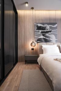 a bedroom with a large bed and a pendant light at ZEST Residence in Kragujevac