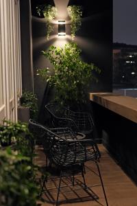 a couple of chairs sitting in front of a plant at ZEST Residence in Kragujevac
