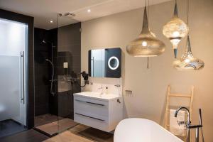 uma casa de banho com um lavatório e um chuveiro. em Boutique Hotel Bed&Bos em Best