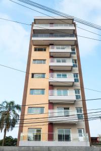 un edificio alto con una palmera delante de él en Edificio Mia Victoria en Oberá