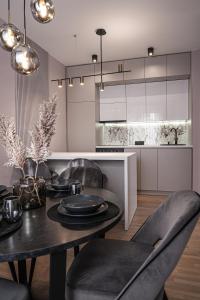 a dining room with a table and chairs and a kitchen at ZEST Residence in Kragujevac