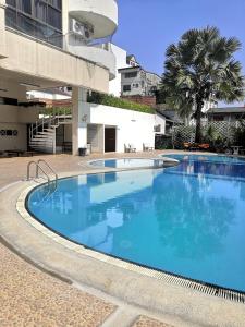 a large blue swimming pool next to a building at 7 pool condo opposite the train station near old city and Nimman in Chiang Mai