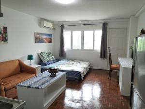 a living room with a bed and a couch at 7 pool condo opposite the train station near old city and Nimman in Chiang Mai