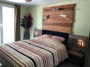 a bedroom with a bed with a wooden headboard at Ti Kaz Furcy in Saint-Louis