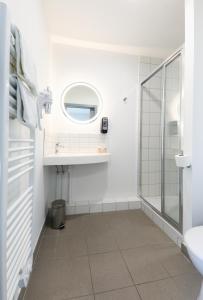 een badkamer met een douche en een wastafel bij The Originals City, Hôtel Mulhouse Est in Rixheim