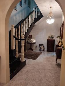 eine Treppe in einem Wohnzimmer mit einem Kronleuchter in der Unterkunft St Julian's Twin Room In A Private House in St Julian's