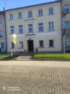 um edifício branco com uma rua em frente em Apartament Miodownik em Międzylesie