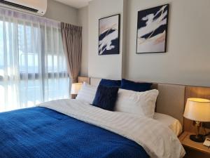 een slaapkamer met een blauw en wit bed en een raam bij Astra Sky River Luxury Perfect For 5 People in Chiang Mai +40 foto's