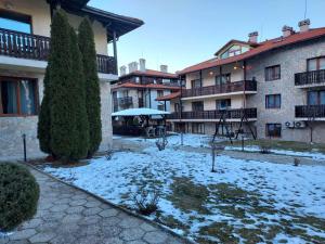 a courtyard covered in snow in front of a building at 4 Seasons 2 - Top Lodge in Bansko