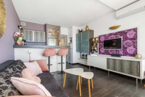 uma sala de estar com um sofá e uma televisão em La vie en rose naturiste - Port Nature em Cap d'Agde