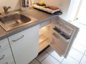 a kitchen with a sink and an open refrigerator at Wo München am schönsten ist in Grünwald