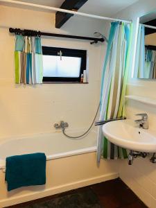 een badkamer met een bad en een wastafel bij Vissershuisje 6 te Koksijde in Koksijde