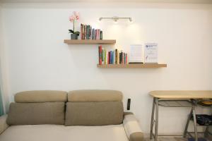 ein Sofa in einem Zimmer mit Tisch und Büchern in der Unterkunft Puteh Homestay in Shah Alam