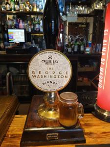 a glass vase and a jar of honey on a table at George Washington Inn in Carnforth