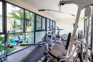 a gym with several treadmills and elliptical machines at Daimond Exclusive Junior Suite Bangtau Beach in Bang Tao Beach