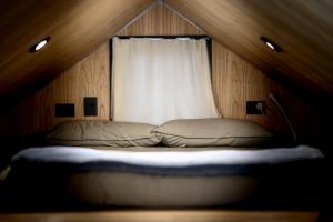 a bed in a room with a window at Encuentro Silvestre. Tiny house en Lago Lolog in San Martín de los Andes