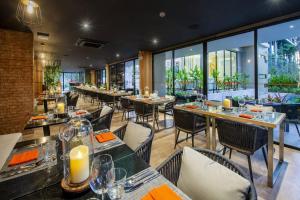 a restaurant with tables and chairs and large windows at Daimond Exclusive Junior Suite Bangtau Beach in Bang Tao Beach