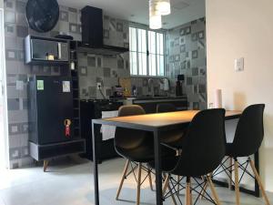 cocina con mesa, sillas y nevera en Apartamentos Aconchegantes Bingen em Petrópolis, en Petrópolis