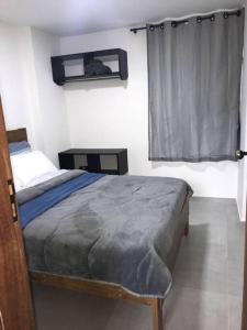 niewielka sypialnia z łóżkiem i oknem w obiekcie Apartamentos Aconchegantes Bingen em Petrópolis w mieście Petrópolis