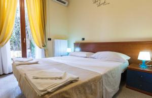 una camera da letto con un grande letto con asciugamani di Hotel Greco a Milano