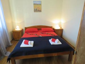 a bedroom with a bed with red and white pillows at Apartments JoDi pool Novalja in Novalja