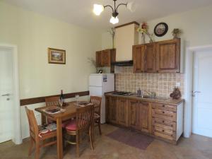 a kitchen with a table and a sink and a refrigerator at Apartments JoDi pool Novalja in Novalja