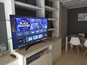 a large flat screen tv sitting on top of a cabinet at Apartamento con PARKING PRIVADO GRATIS INCLUIDO in Córdoba