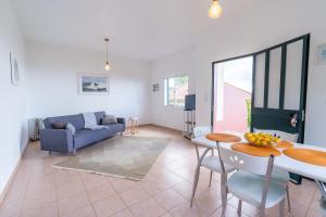 a living room with a table and a couch at Bungalows Do Amparo in Ponta do Pargo