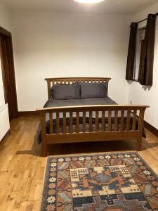 a bedroom with a wooden bed with a rug at Ridge Wood House in Armagh