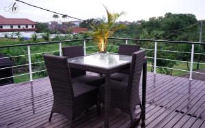 a glass table and chairs on a deck at AA GUESTHOUSE in Canggu