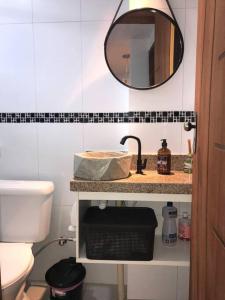 a bathroom with a sink and a mirror at Apartamentos Aconchegantes Bingen em Petrópolis in Petrópolis