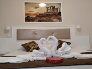 Dos cisnes hechos de toallas en una cama en OLYMPUS ROOM en Tropea