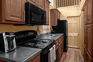 a kitchen with a stove and a microwave at Sun Outdoors North Moab in Moab