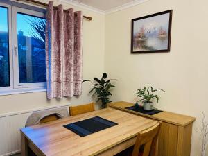una mesa de madera en una habitación con ventana en St Ives, King Bed Cosy home, parking, fast Wi Fi en St Ives