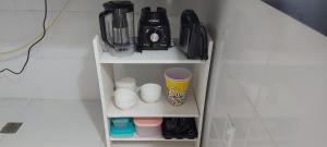 a shelf with cups and other items on it at Caribean's house in Arraial do Cabo