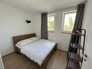 a small bedroom with a bed and a window at Chateau Kravín - Celý objekt 15 pokojů a stodola 