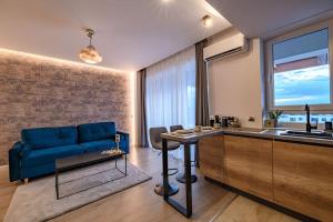 Il comprend un salon avec un canapé bleu et une cuisine. dans l'établissement BRAVISA Apart View, à Braşov
