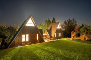 uma casa com um jardim relvado com um parque infantil em AKORD chata em Námestovo