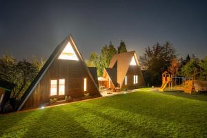 a house with a grassy yard with a playground at AKORD chata in Námestovo