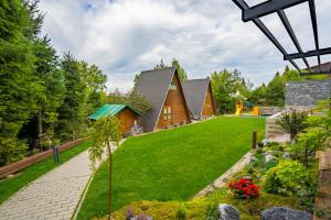 une maison dans les bois avec une pelouse dans l'établissement AKORD chata, à Námestovo