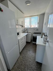 cocina con electrodomésticos blancos y nevera blanca en Acacias IV 15A en Benidorm