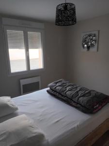 a bed with a blanket on top of it in a bedroom at L'Instant Présent, en Vendée, gite neuf , 3 etoiles, 15 minutes de l'océan in Saint-Julien-des-Landes