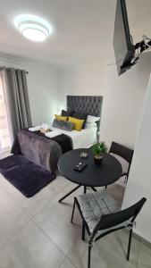 杰米斯顿Marielitsa Guest Suite No 3的一间卧室，配有一张床、一张桌子和几把椅子