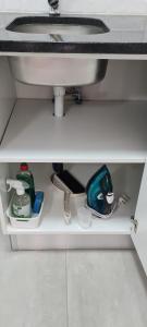 a bathroom sink under a sink with cleaning products at Marielitsa Guest Suite No 3 in Germiston
