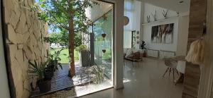 een woonkamer met een glazen schuifdeur met planten bij Family House Los Cuatro Robles in San Pedro