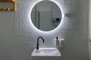 W łazience znajduje się umywalka i lustro. w obiekcie Monte Estoril Train Station - Seaside Apartment w mieście Estoril