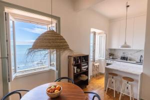 una cucina con tavolo e una finestra con vista sull'oceano di Monte Estoril Train Station - Seaside Apartment a Estoril